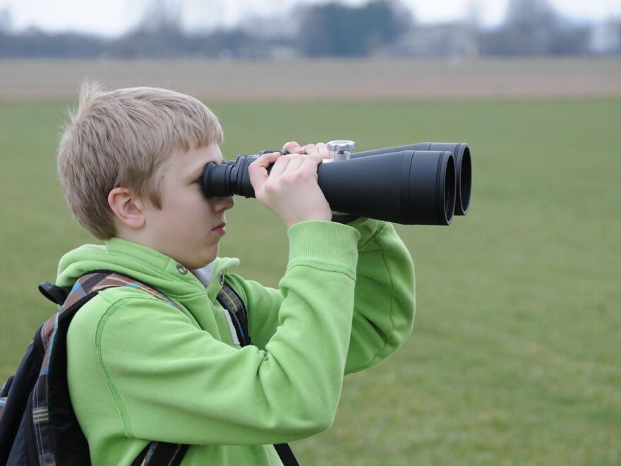 Junge mit zu großem Fernglas als Negativbeispiel für Kinderfernglas