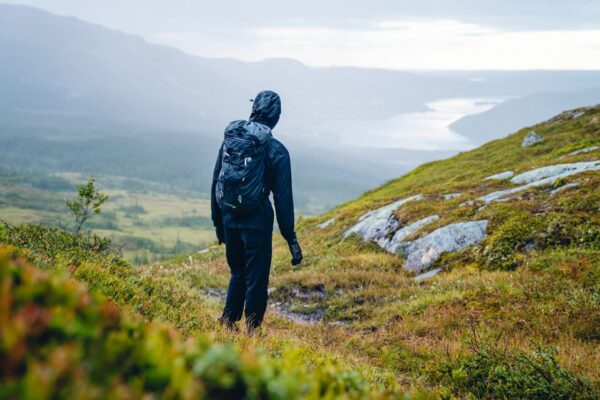 Wetterfest und robust beim Wandern in Regen und Outdoor-Natur Wanderer mit Regenkleidung zeigt wetterfeste Ausrüstung bei Outdoor-Einsatz